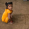 Little girl drawing in dirt