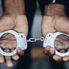 hands holding handcuffs